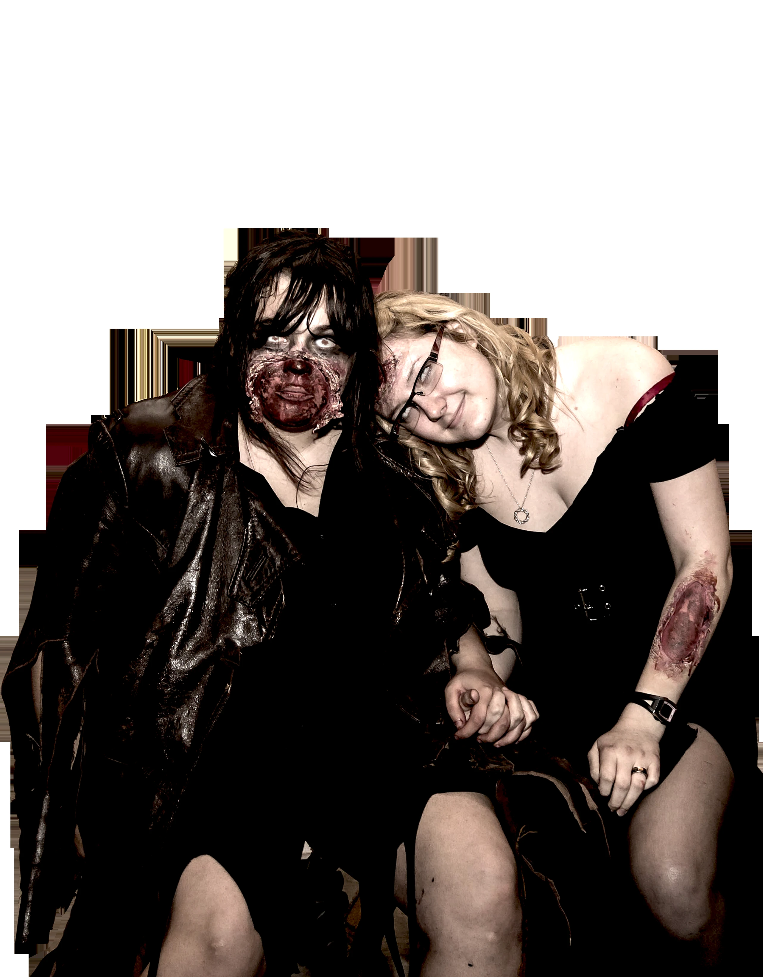 Two women are posing for a picture, one with zombie makeup and a leather jacket, and the other with glasses and a black dress, leaning her head on the first woman's shoulder, against a dark background with vertical and horizontal light streaks.