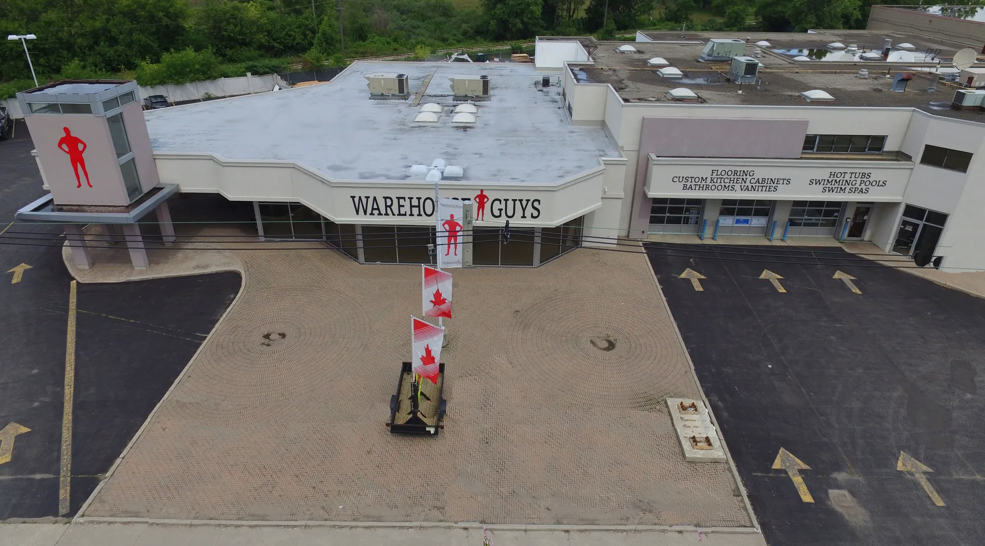 The shop. Aerial of the building, with the whole business written on the sign — flooring, kitchen cabinets, bathrooms, vanities, hot tubs, pools, swim spas.