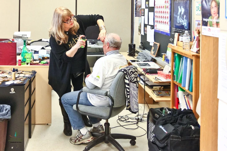 The volunteers. Hair and make-up being done on set — community members becoming a class.